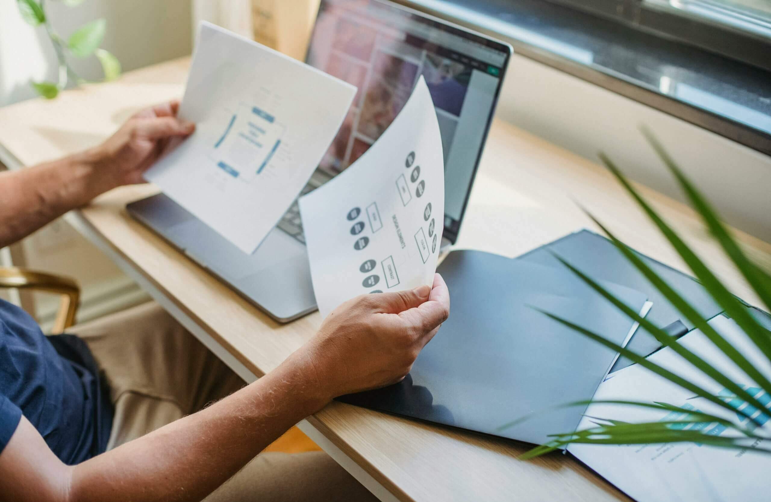 concepteur de site internet assis à son bureau devant un ordinateur portable entrain de travailler sur un nouveau projet de site web