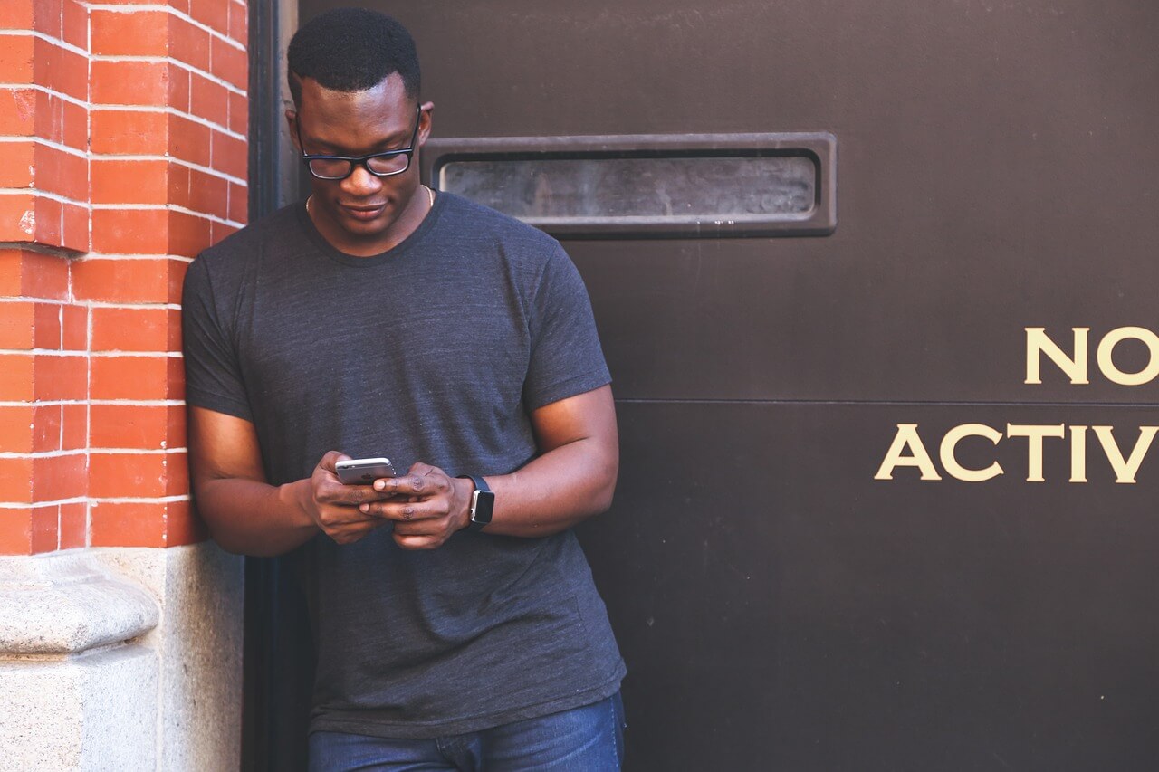 homme consultant un site web depuis son smartphone dans la rue