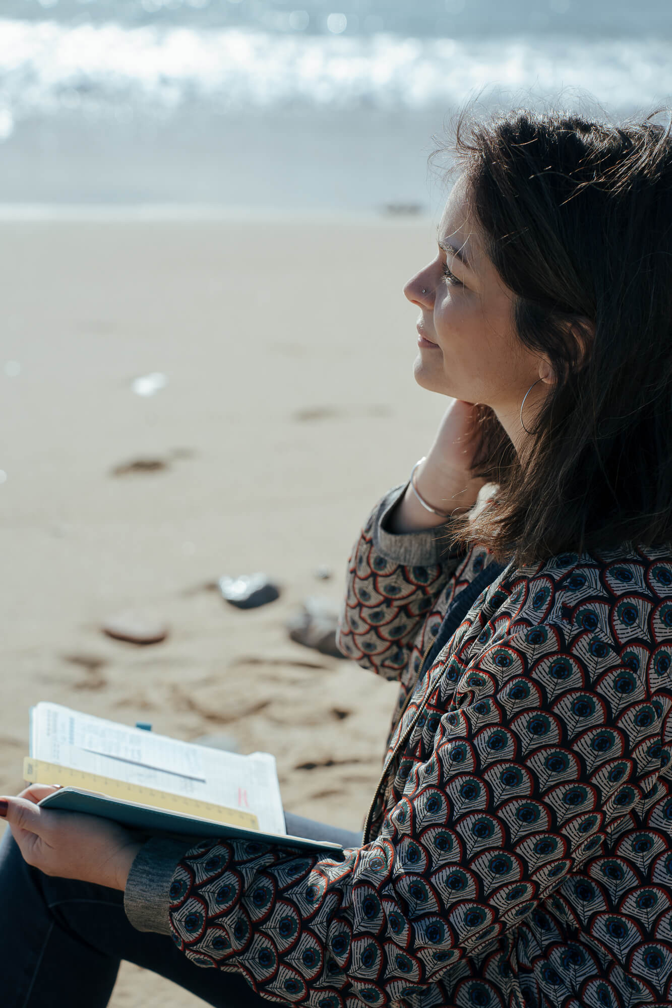 julie rogier réfléchissant sur un projet de rédaction web à la plage 
